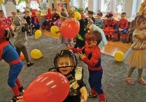 Dzieci bawią się balonami podrzucając je do góry